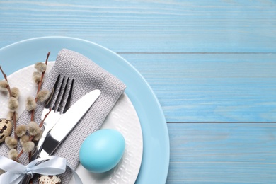 Photo of Festive Easter table setting with egg on light blue wooden background, flat lay. Space for text