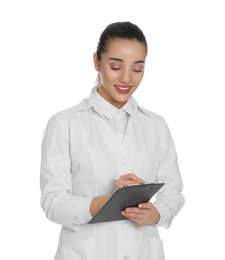 Photo of Happy young woman in lab coat with clipboard on white background