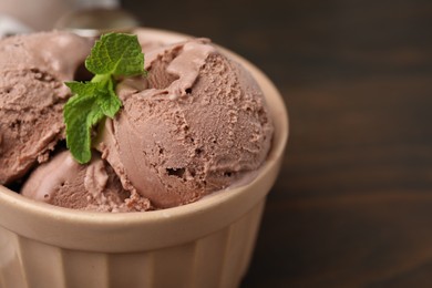 Bowl of tasty chocolate ice cream on table, closeup. Space for text