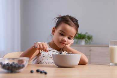 Photo of Cute little girl refusing to eat her breakfast at home