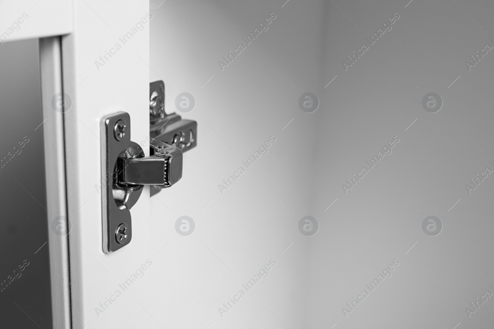 Photo of Door angle hinge in wooden cabinet, closeup