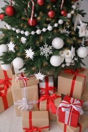 Photo of Gift boxes under decorated Christmas tree indoors