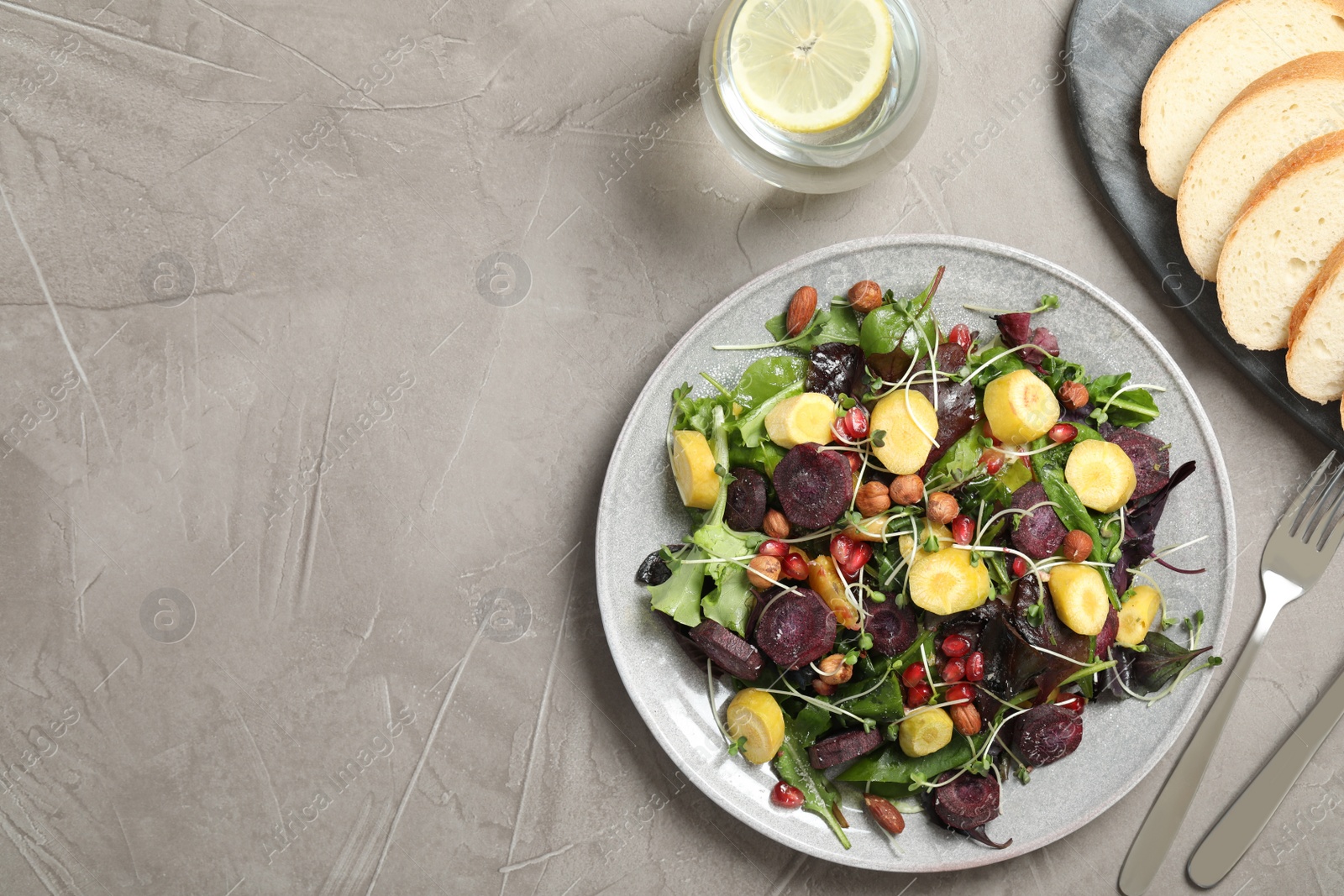 Photo of Delicious fresh carrot salad served on grey table, flat lay. Space for text