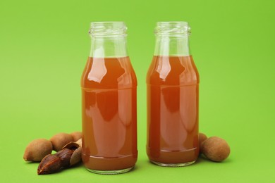 Tamarind juice and fresh fruits on green background