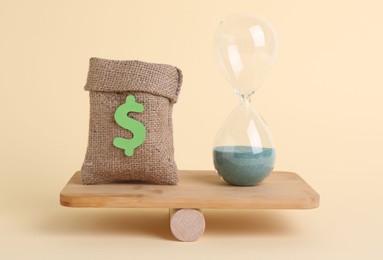 Photo of Equality concept. Burlap sack of money, hourglass with sand and seesaw scale on beige background