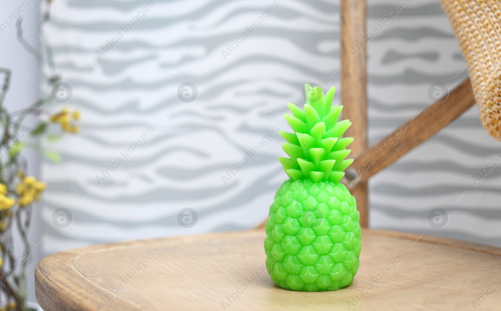 Photo of Pineapple shaped candle on table in room