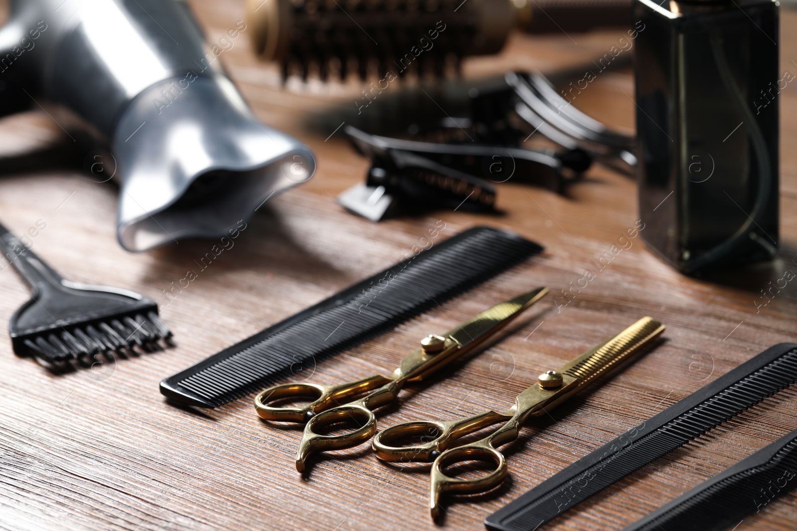 Photo of Hairdresser tools. Different scissors and combs on wooden table, closeup