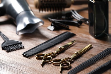 Hairdresser tools. Different scissors and combs on wooden table, closeup