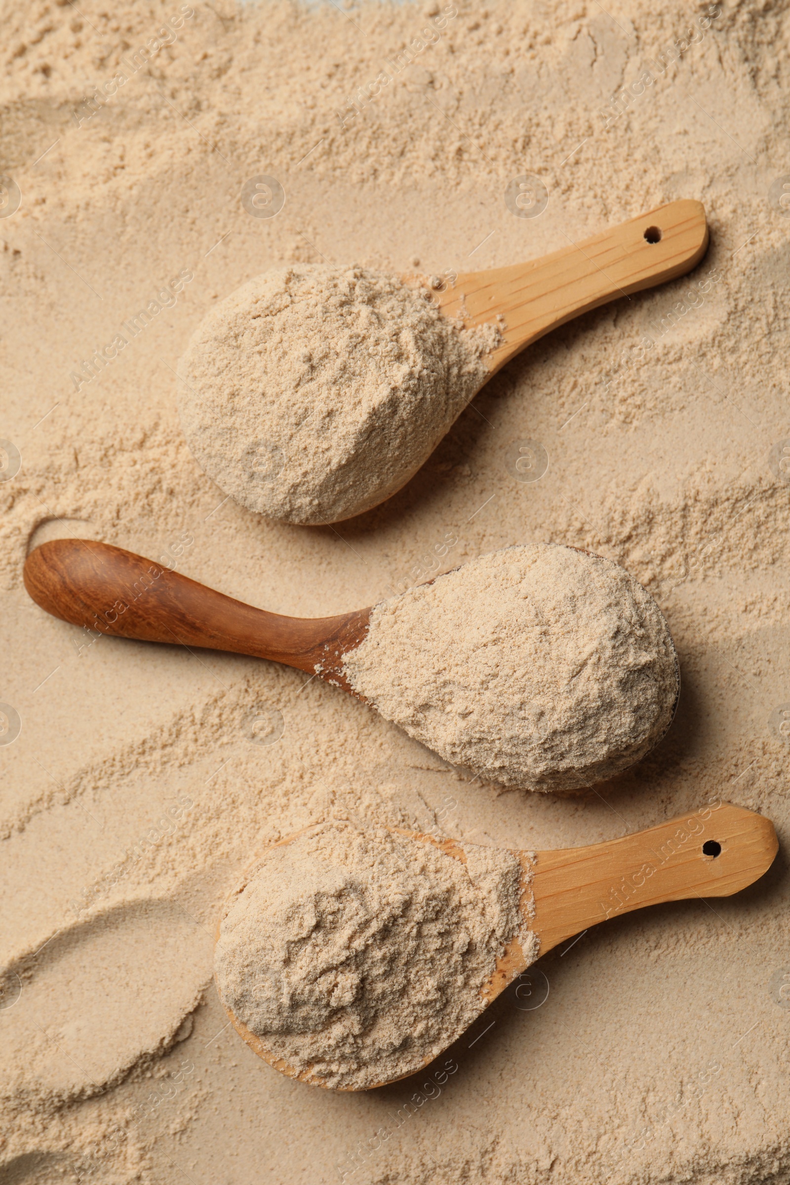 Photo of Buckwheat flour and wooden spoons, top view