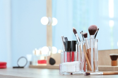 Organizer with cosmetic products for makeup on table near mirror. Space for text