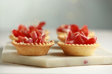 Photo of Delicious canapes with jamon on white table, closeup