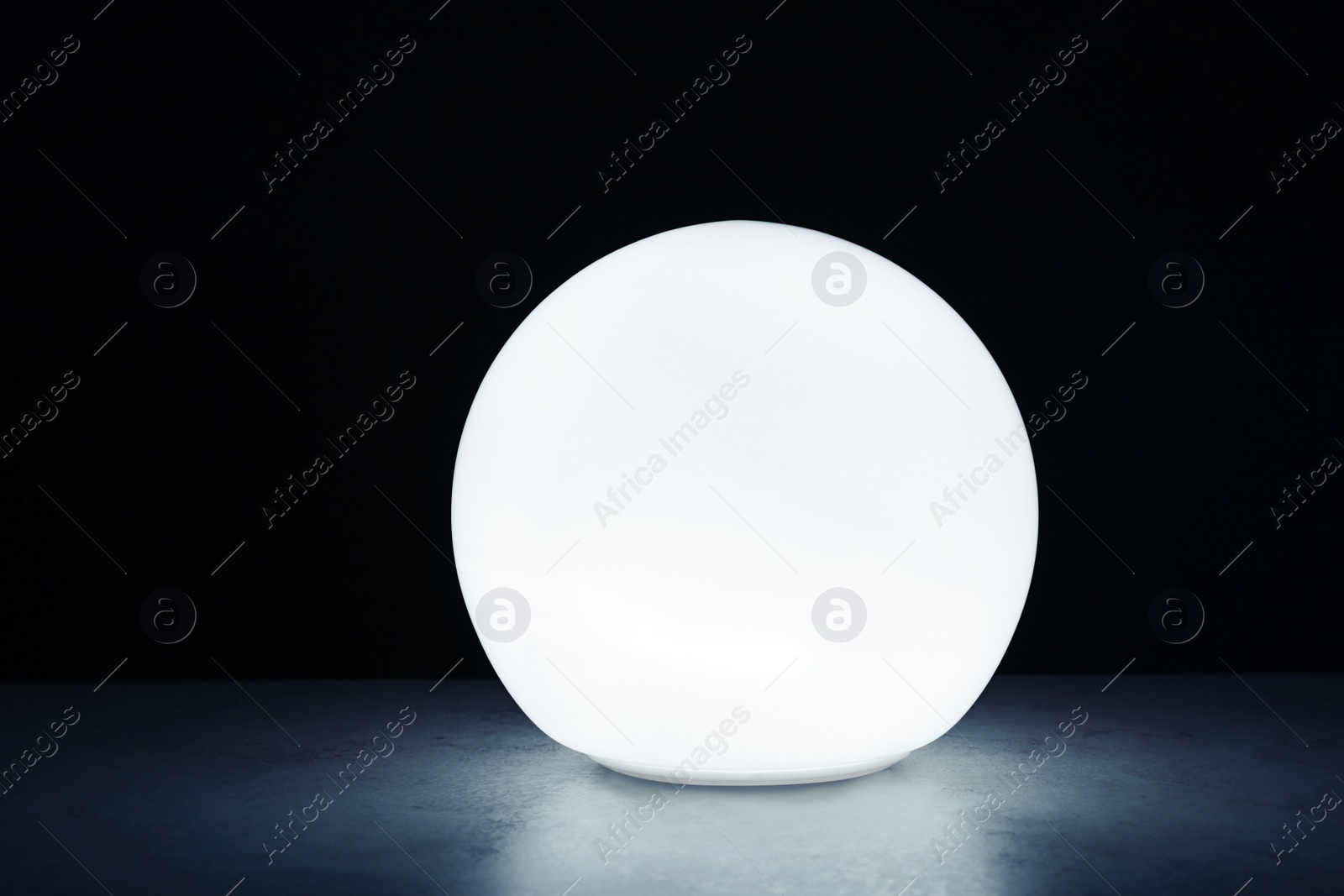 Photo of Glowing prediction ball on table in darkness. Fortune telling