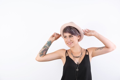 Photo of Trendy young woman with tattoos on white background. Space for text