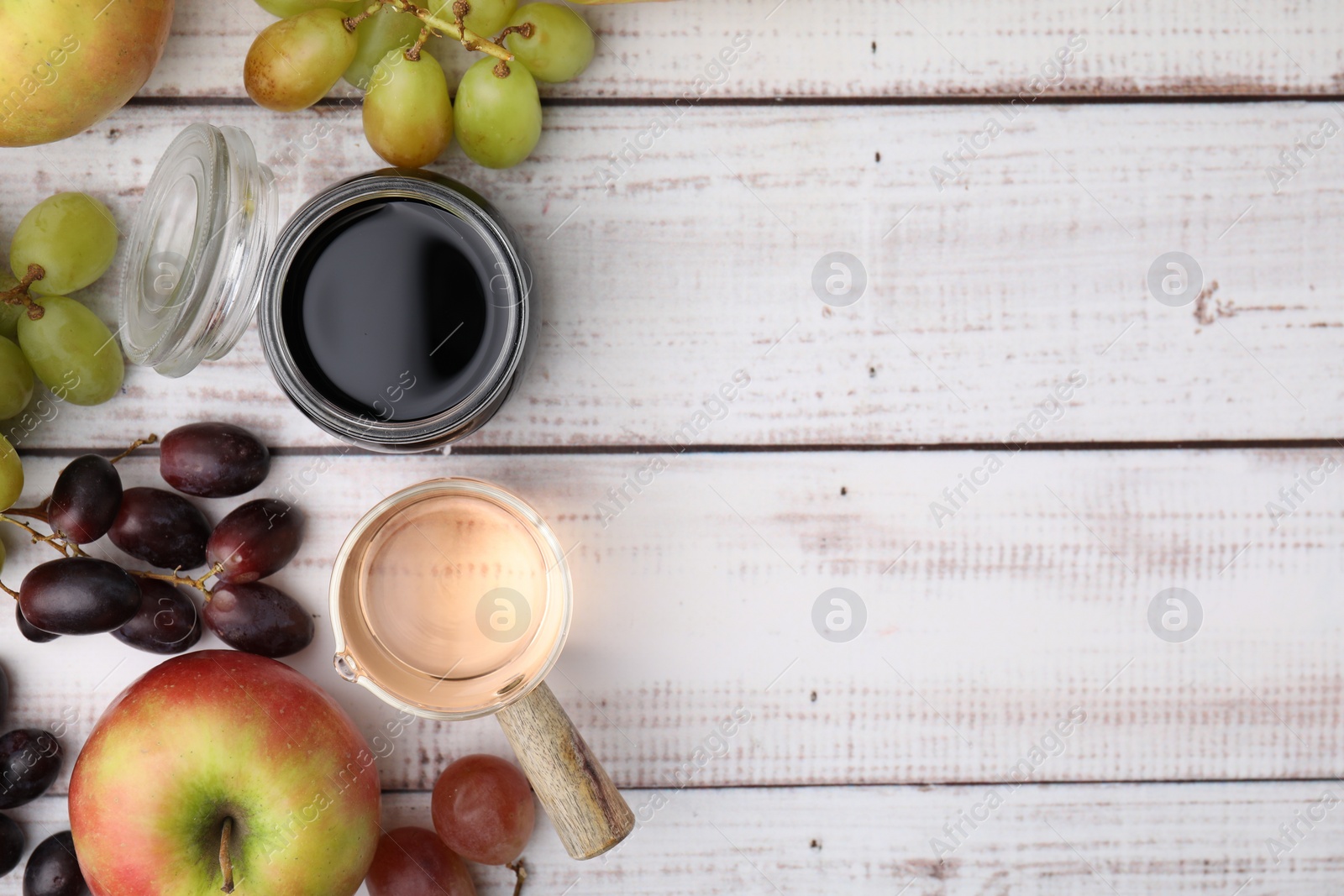 Photo of Different types of vinegar and ingredients on wooden table, flat lay. Space for text