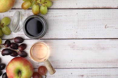 Photo of Different types of vinegar and ingredients on wooden table, flat lay. Space for text