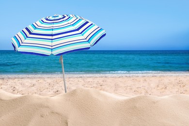 Open big beach umbrella on sandy coast 