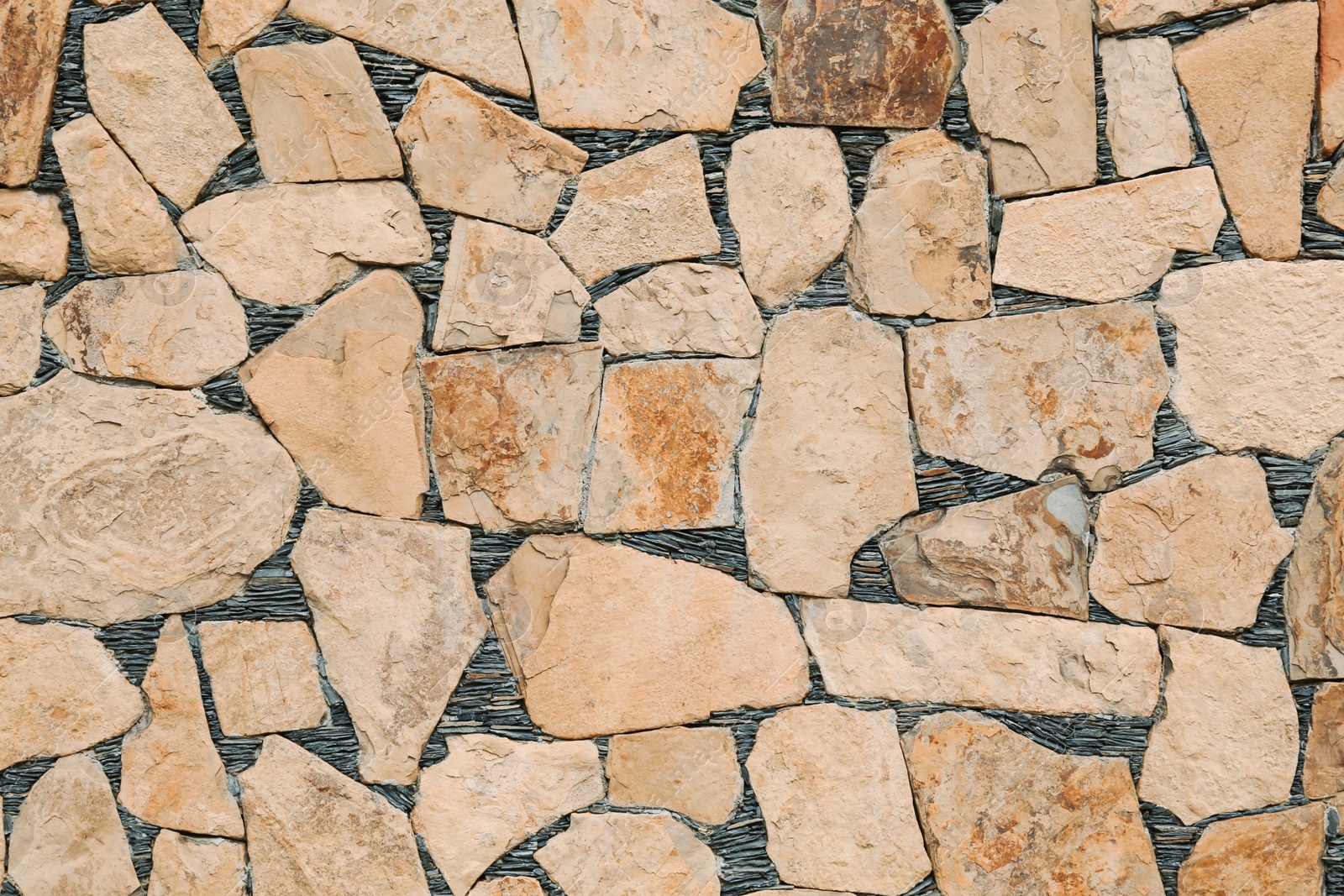 Photo of Beautiful yellow stone wall as background, closeup