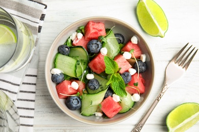 Photo of Delicious salad with watermelon served on white wooden table, flat lay