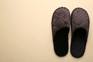 Photo of Pair of soft slippers on beige background, flat lay. Space for text