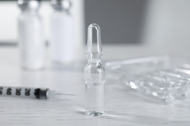 Photo of Pharmaceutical ampoule with medication on white wooden table