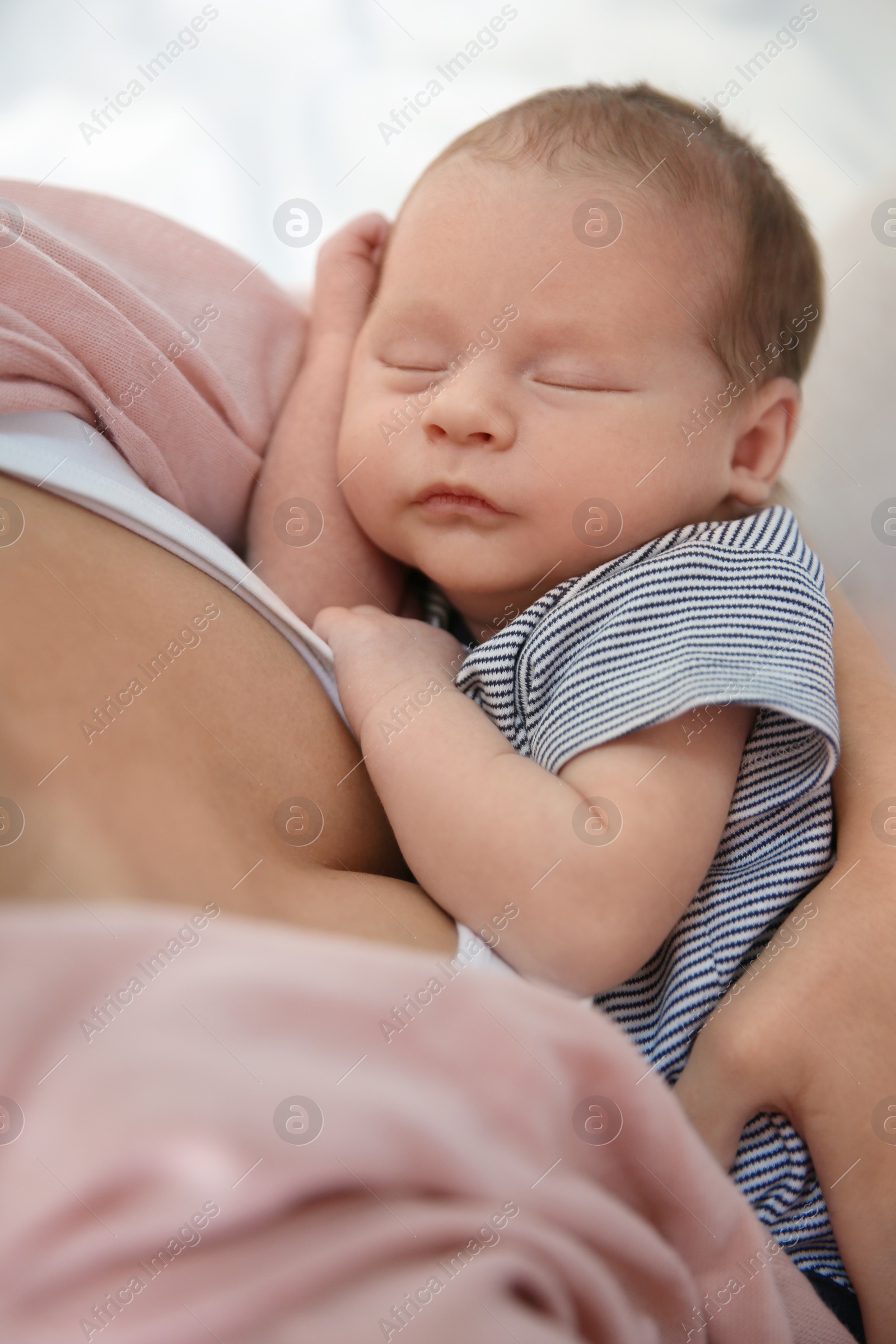 Photo of Young woman holding her newborn baby, closeup