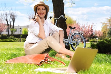 Photo of Woman talking on phone during work in park