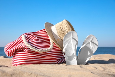 Photo of Set with stylish beach accessories on sand near sea