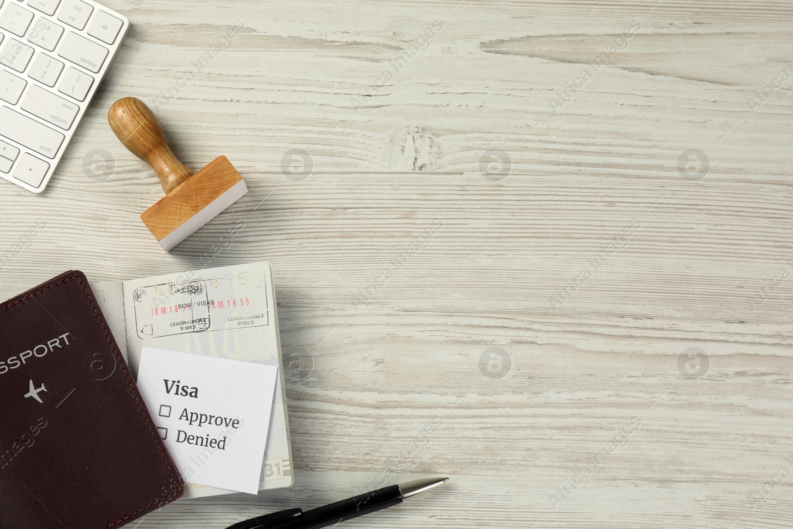 Photo of Moldova, Ceadir-Lunga - June 13, 2022: Flat lay composition with visa stamp, passports and pen on white wooden table. Space for text