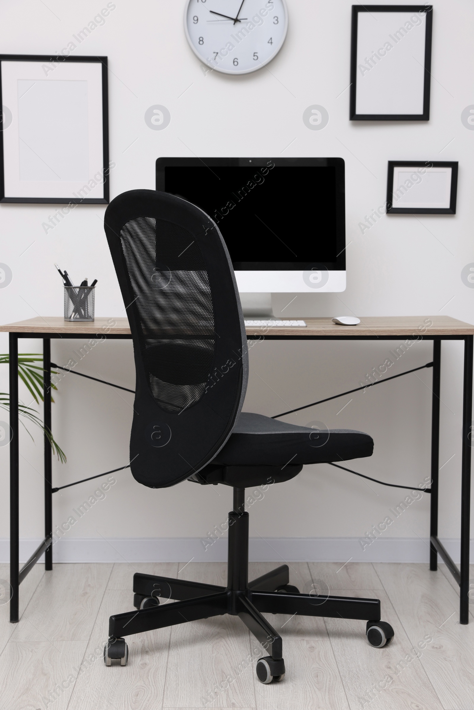 Photo of Comfortable office chair near desk in modern workplace