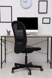 Comfortable office chair near desk in modern workplace