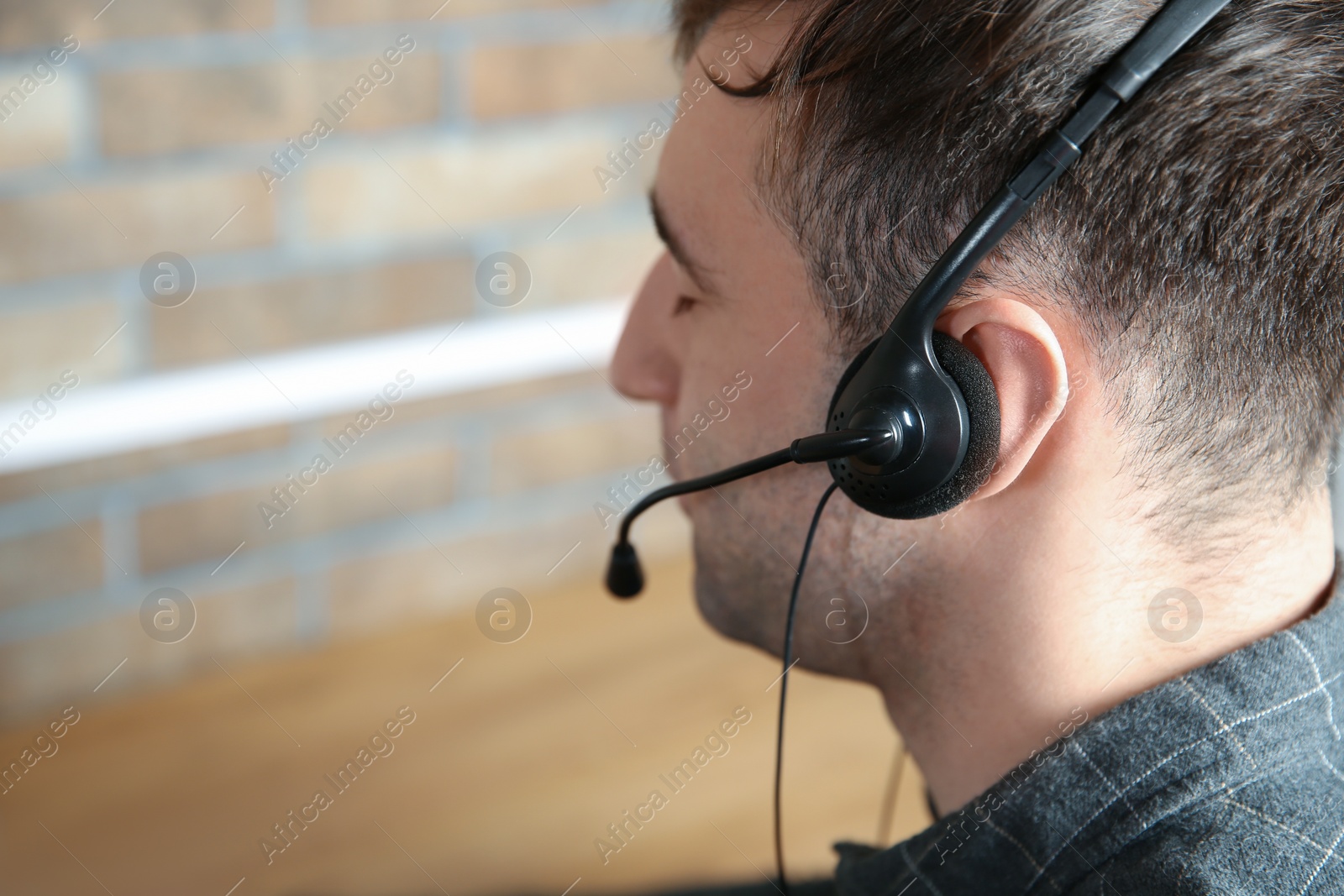 Photo of Male technical support operator with headset at workplace