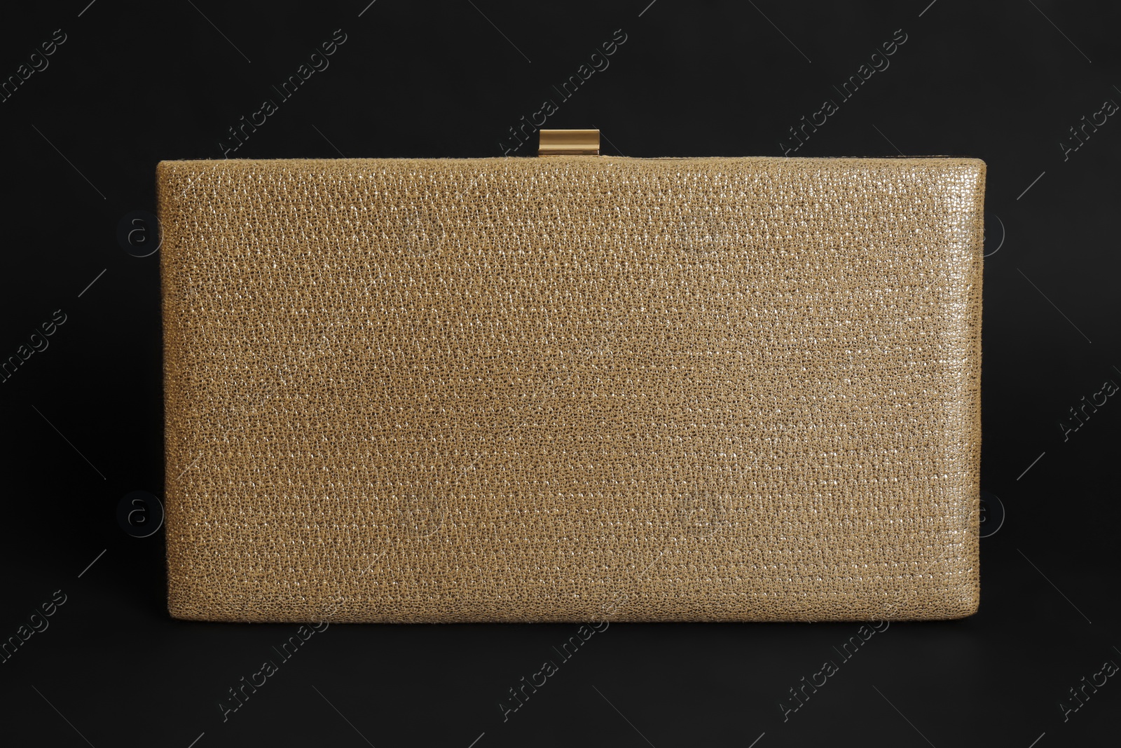 Photo of Elegant new gold clutch on black background