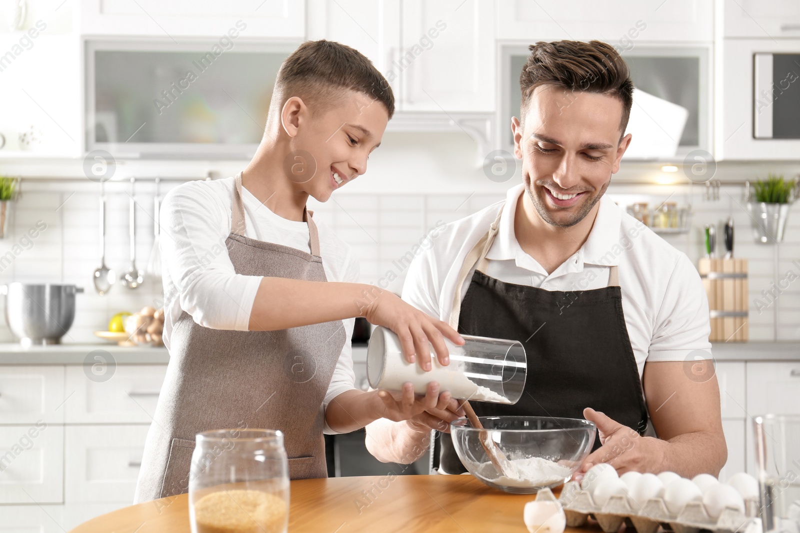 Photo of Dad and son cooking together in kitchen