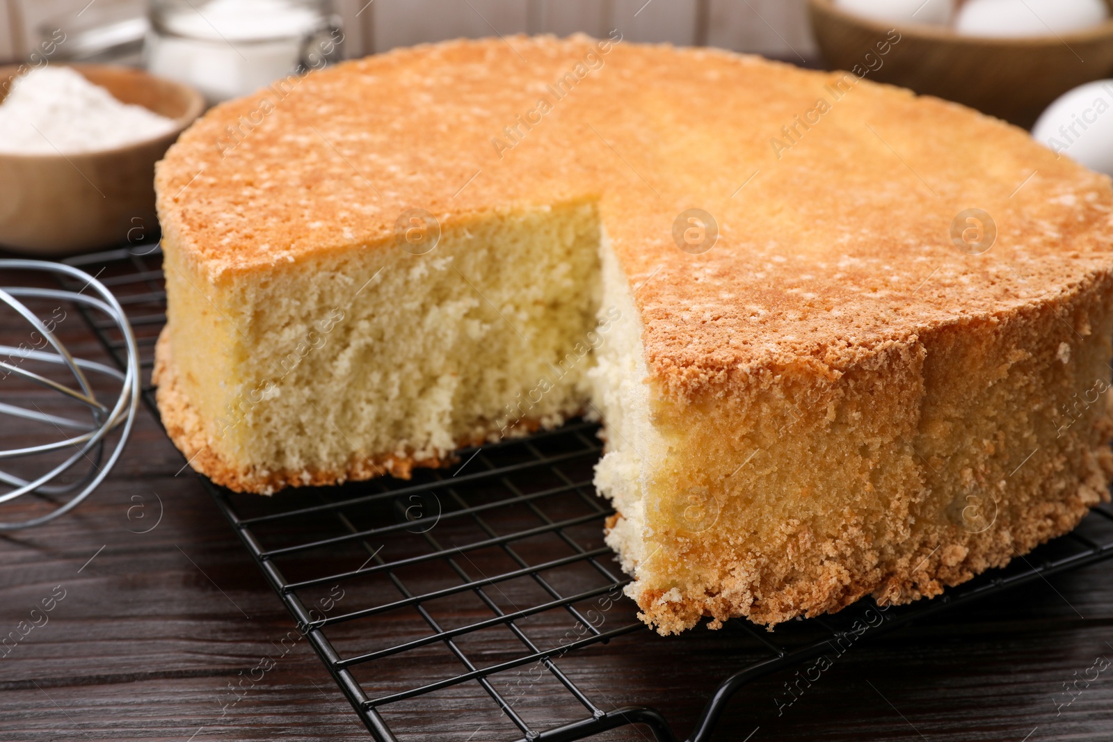 Photo of Tasty sponge cake on wooden table, closeup