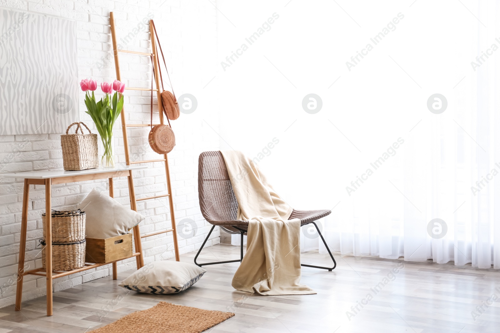 Photo of Stylish living room interior with cozy armchair near brick wall. Space for text