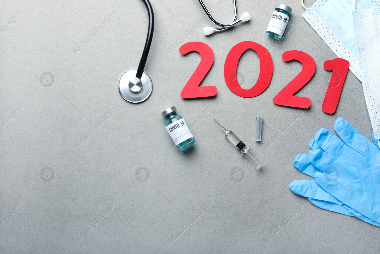 Photo of Flat lay composition with coronavirus vaccine and number 2021 on grey background. Space for text