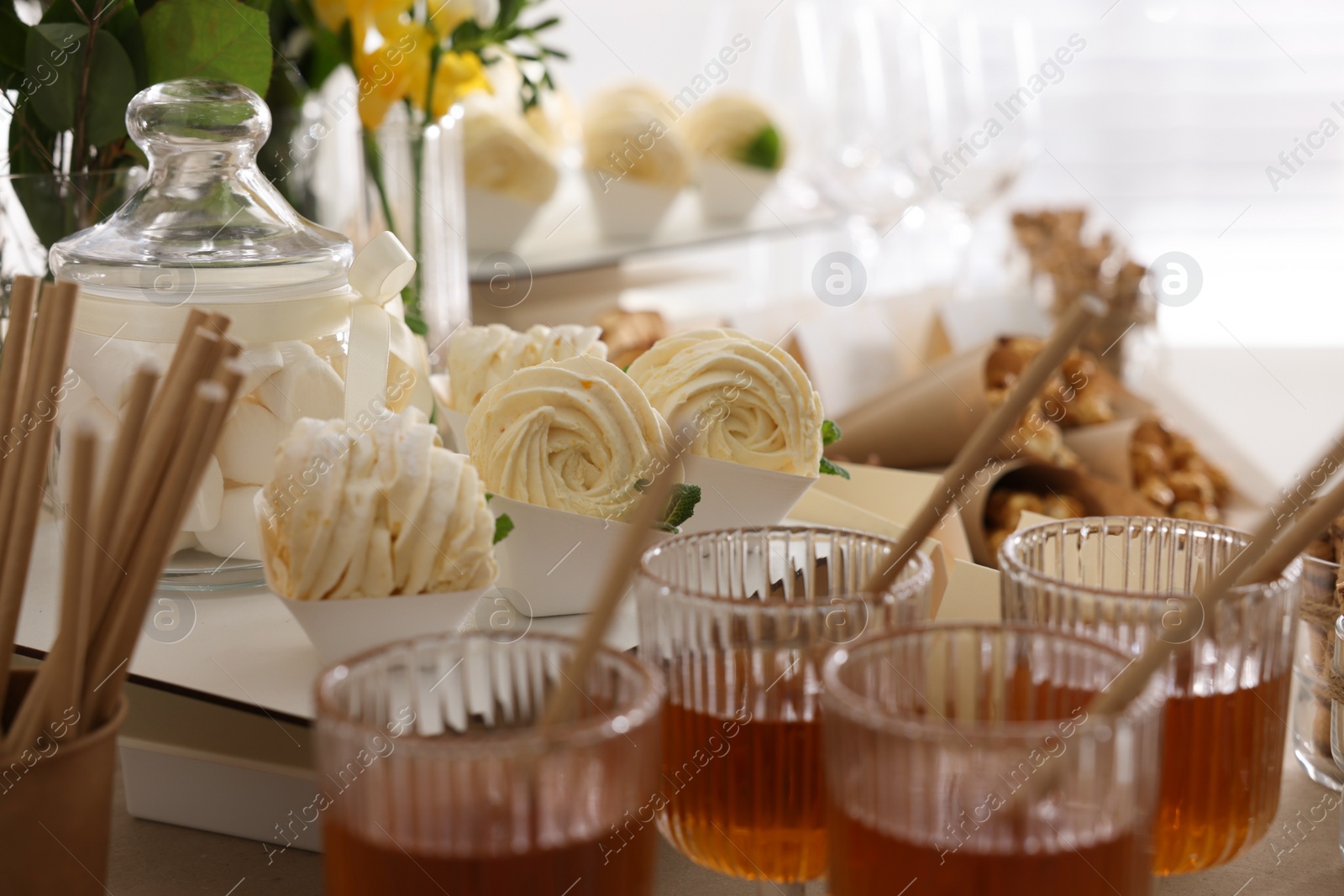 Photo of Tasty treats and glasses of drink on table. Sweet buffet