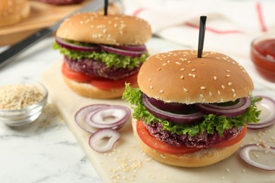 Photo of Tasty vegetarian burgers with beet patties on white marble table, closeup