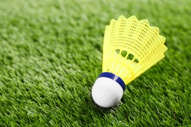 Photo of Badminton shuttlecock on green grass outdoors, closeup. Space for text