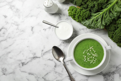 Photo of Tasty kale soup served on white marble table, flat lay. Space for text