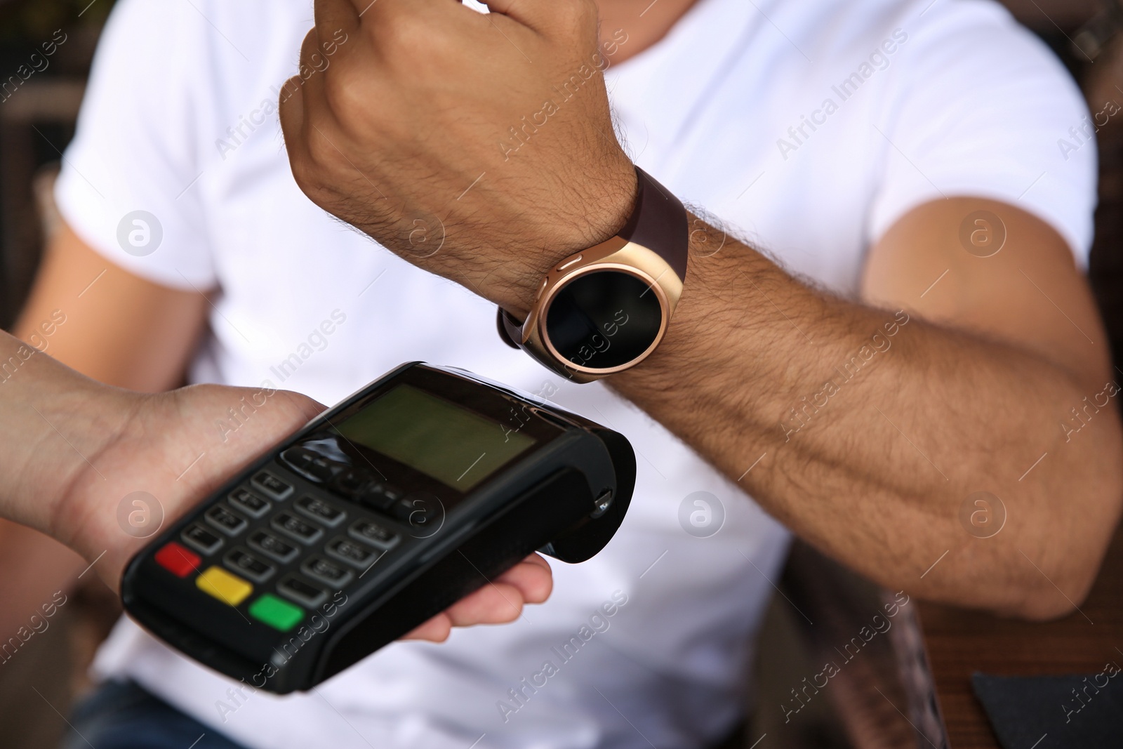 Photo of Man making payment with smart watch outdoors, closeup