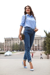 Beautiful woman in elegant shoes walking on street