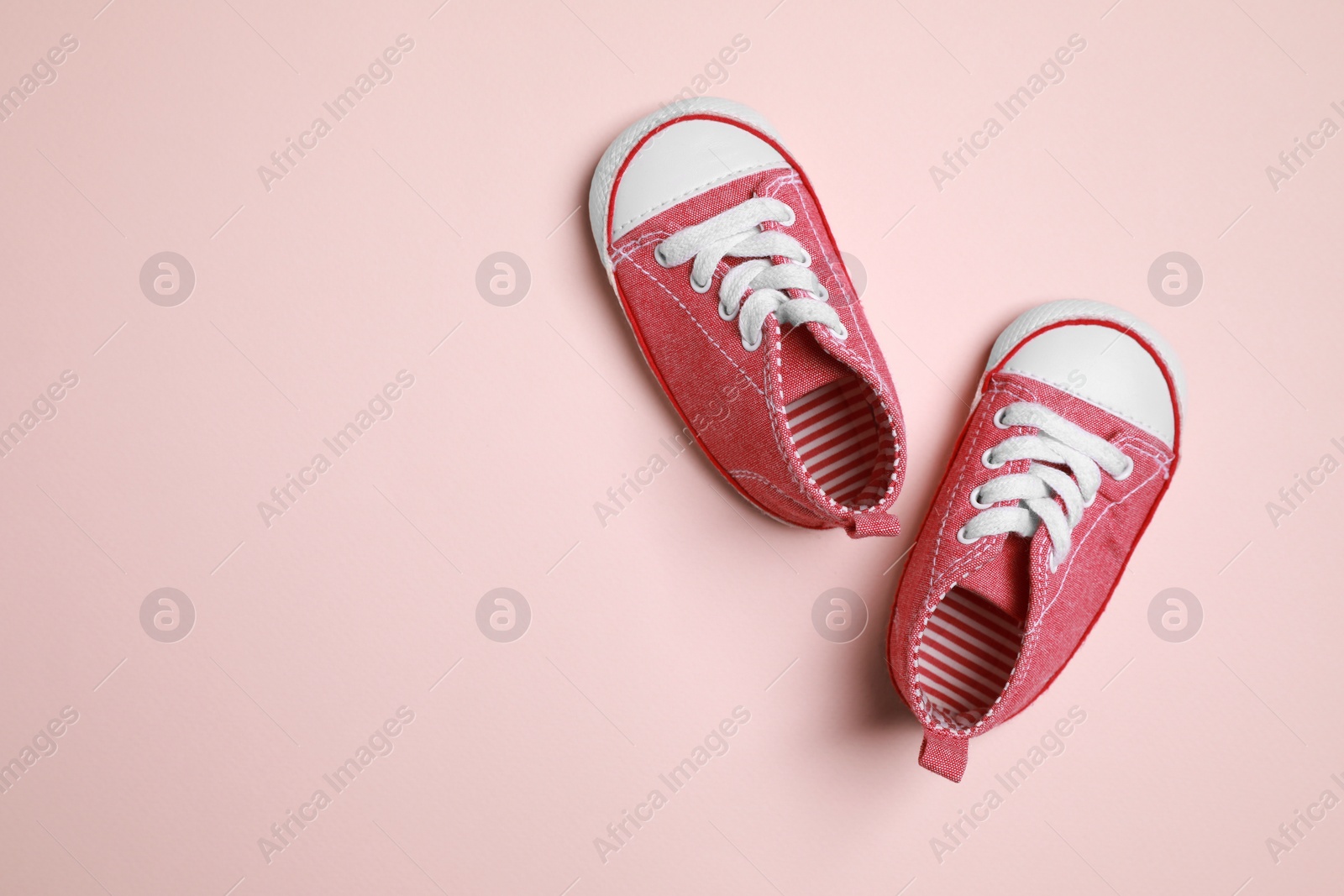 Photo of Cute baby shoes on beige background, flat lay. Space for text