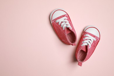 Photo of Cute baby shoes on beige background, flat lay. Space for text