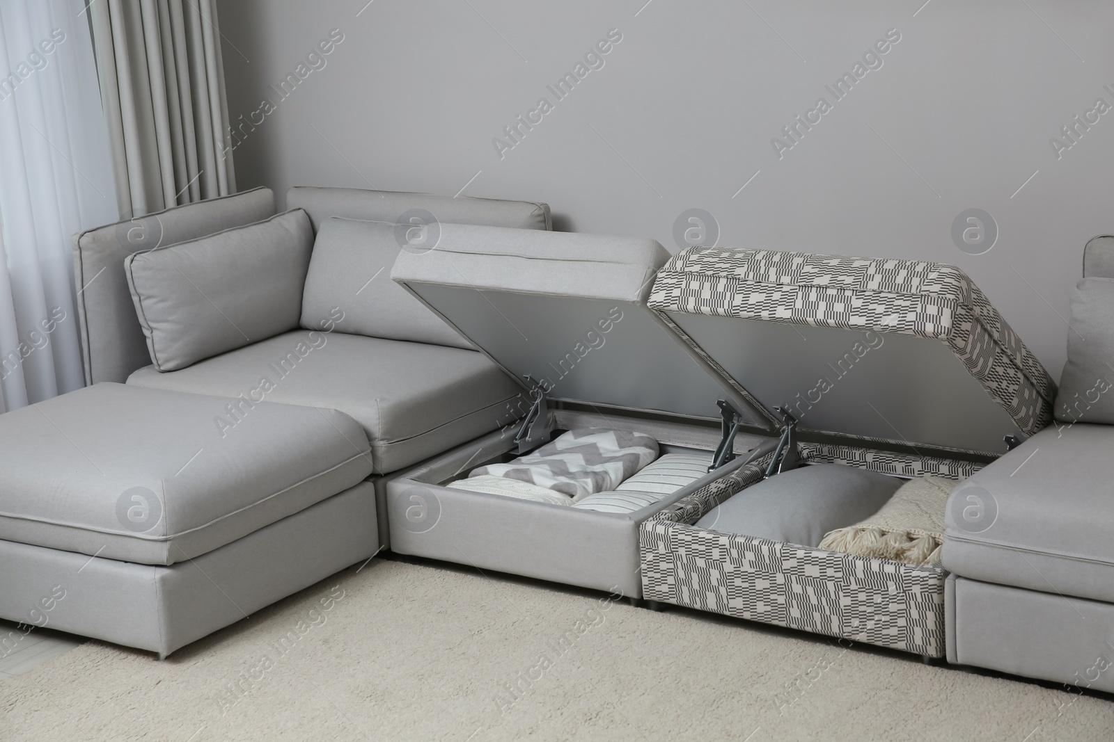 Photo of Modular sofa with storage near wall in living room. Interior design
