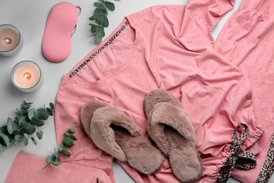 Photo of Flat lay composition with fluffy slippers and pajamas on grey background. Comfortable home outfit