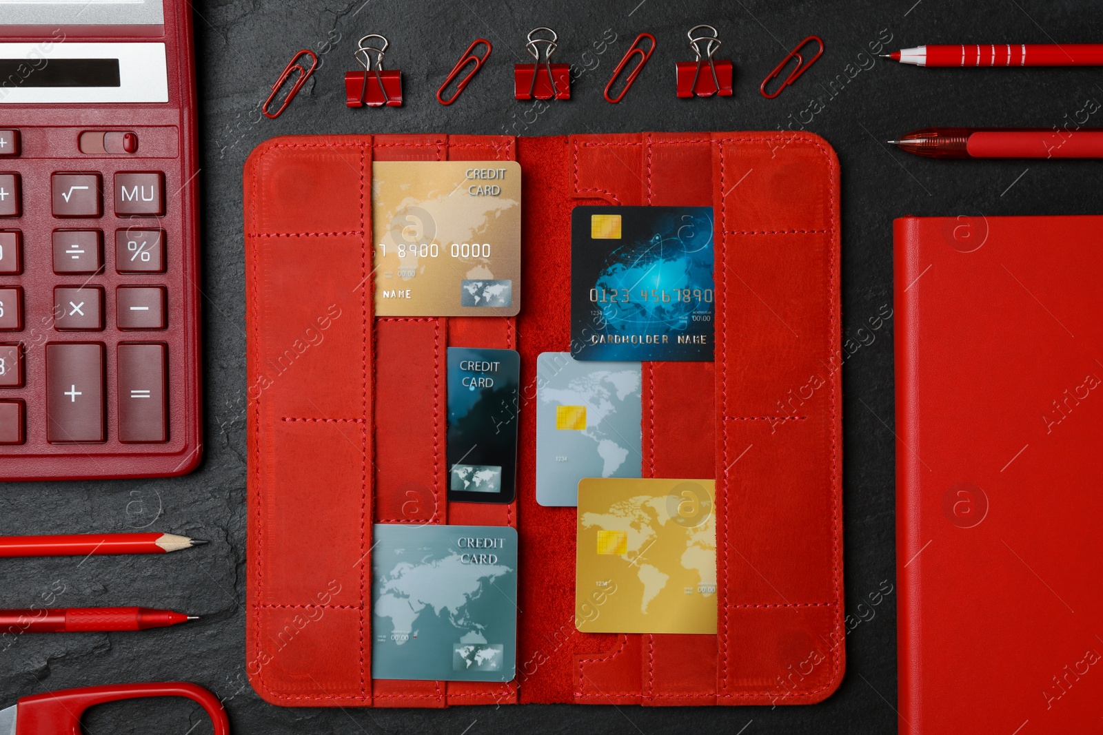 Photo of Flat lay composition with credit cards, calculator and stationery on black background