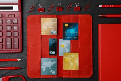 Flat lay composition with credit cards, calculator and stationery on black background