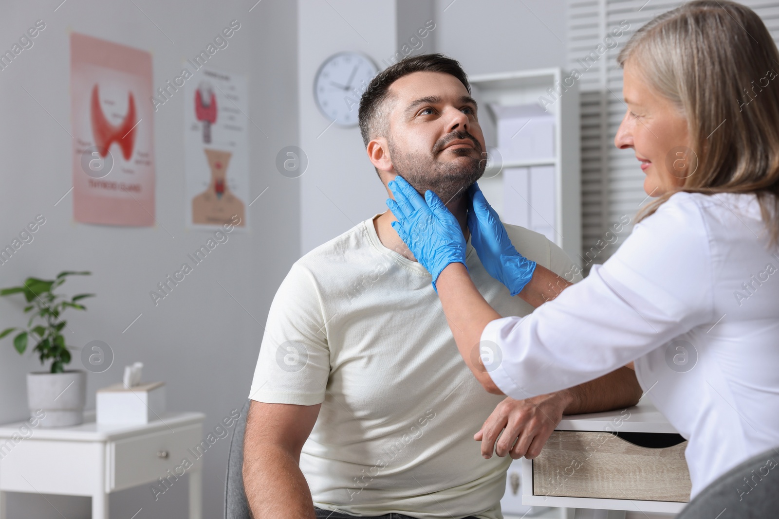 Photo of Endocrinologist examining thyroid gland of patient at hospital