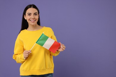 Photo of Happy young woman with flag of Italy on violet background, space for text